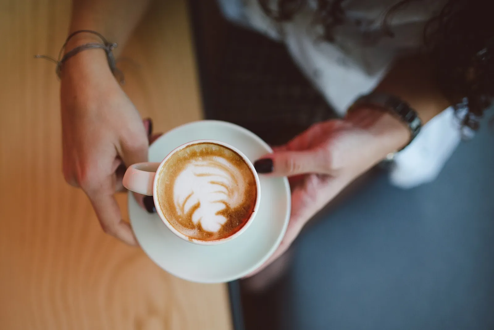 A cappuccino with latte art on a cafe table. The photo was not taken in Coral Gables.